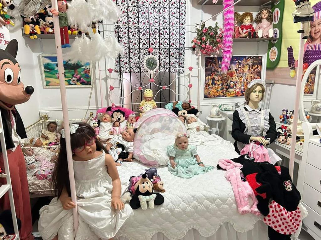 The baby in the green dress, on the bed, is Isabella - Silvia's first Reborn Doll. This gift from her daughters sparked her love and interest in doll-collecting.
